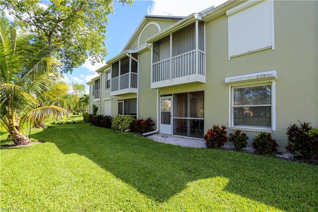 287 Quail Forest Boulevard, Unit 117 Naples, FL 34105 - Photo 24 of 29 a front view of a house with a yard and porch