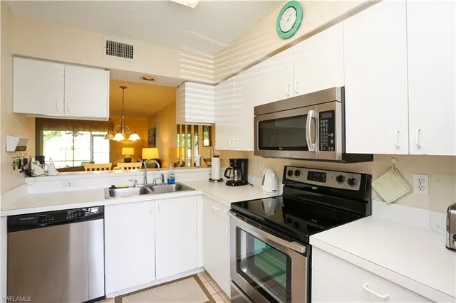 a kitchen with a sink a stove and cabinets