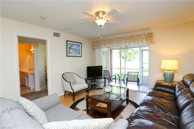 a living room with furniture a flat screen tv and a large window