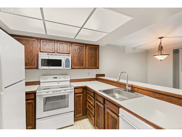 a kitchen with stainless steel appliances granite countertop a sink stove a microwave and refrigerator