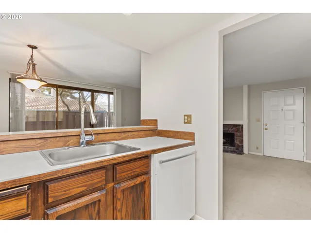 a view of a kitchen with a sink and large window