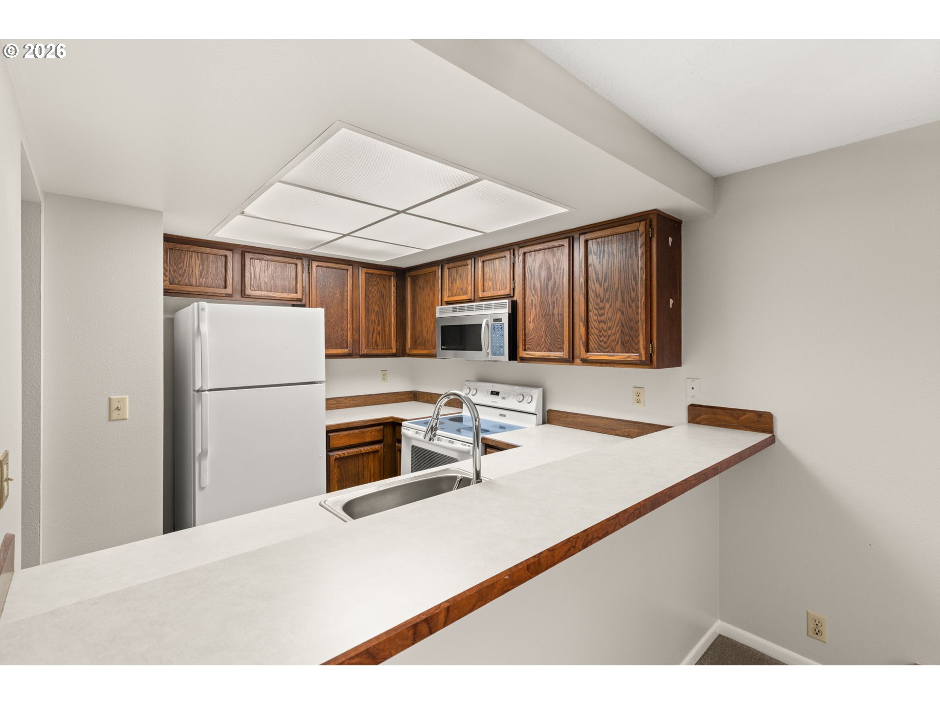 14720 Southwest Grayling Lane Beaverton, OR 97007 - Photo 17 of 32 a kitchen with kitchen island a stove a sink and a refrigerator