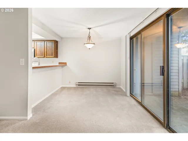 an empty room with windows and cabinet