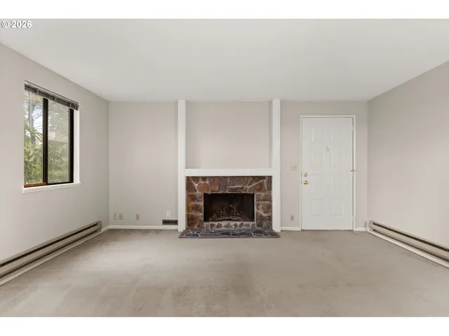 an empty room with fireplace and a window