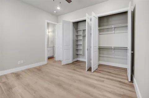 a view of an empty room with wooden floor closet and entryway