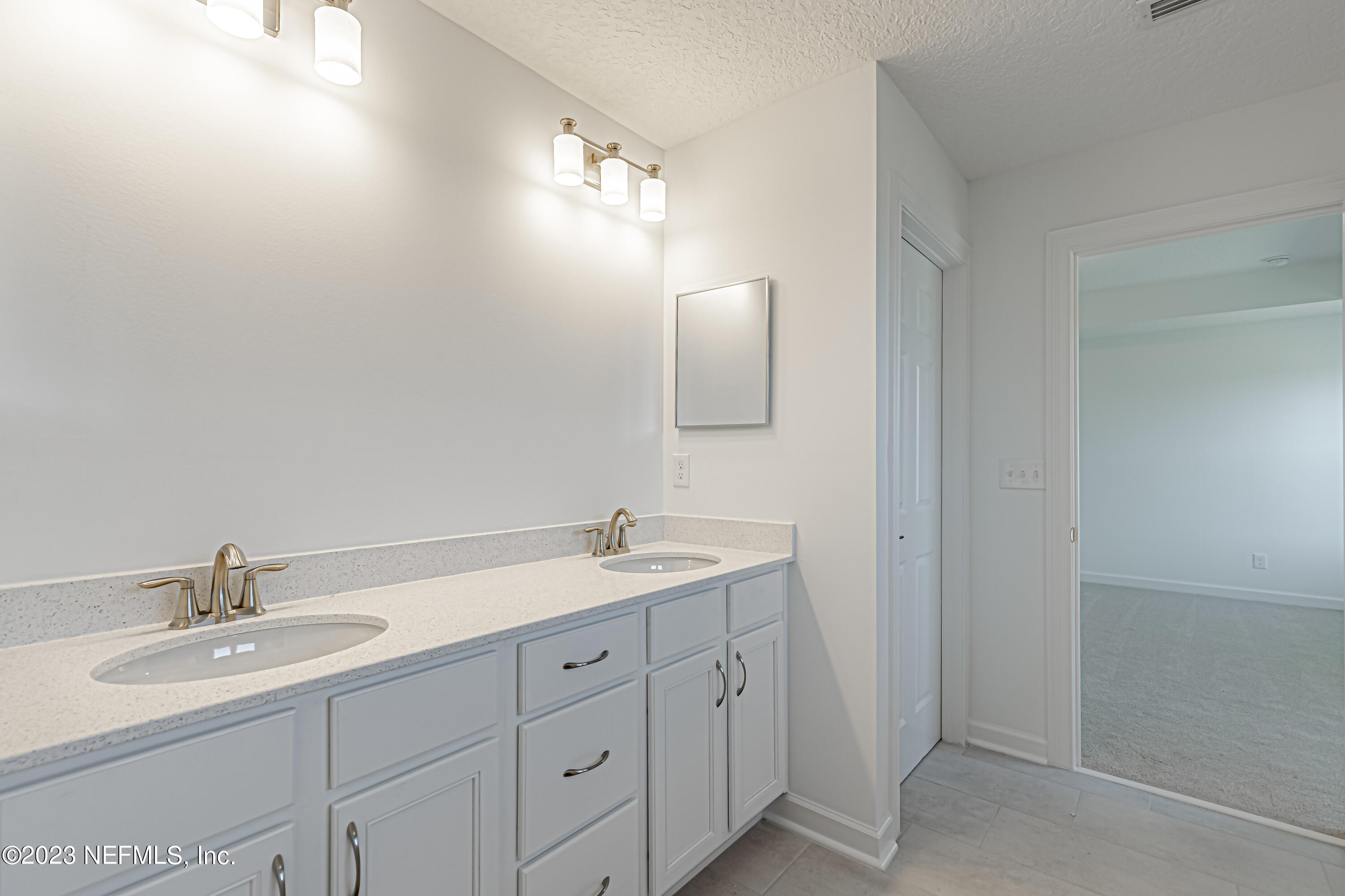 3057 Orange Picker Road Jacksonville, FL 32223 - Photo 17 of 21 a bathroom with a double vanity sink and a mirror
