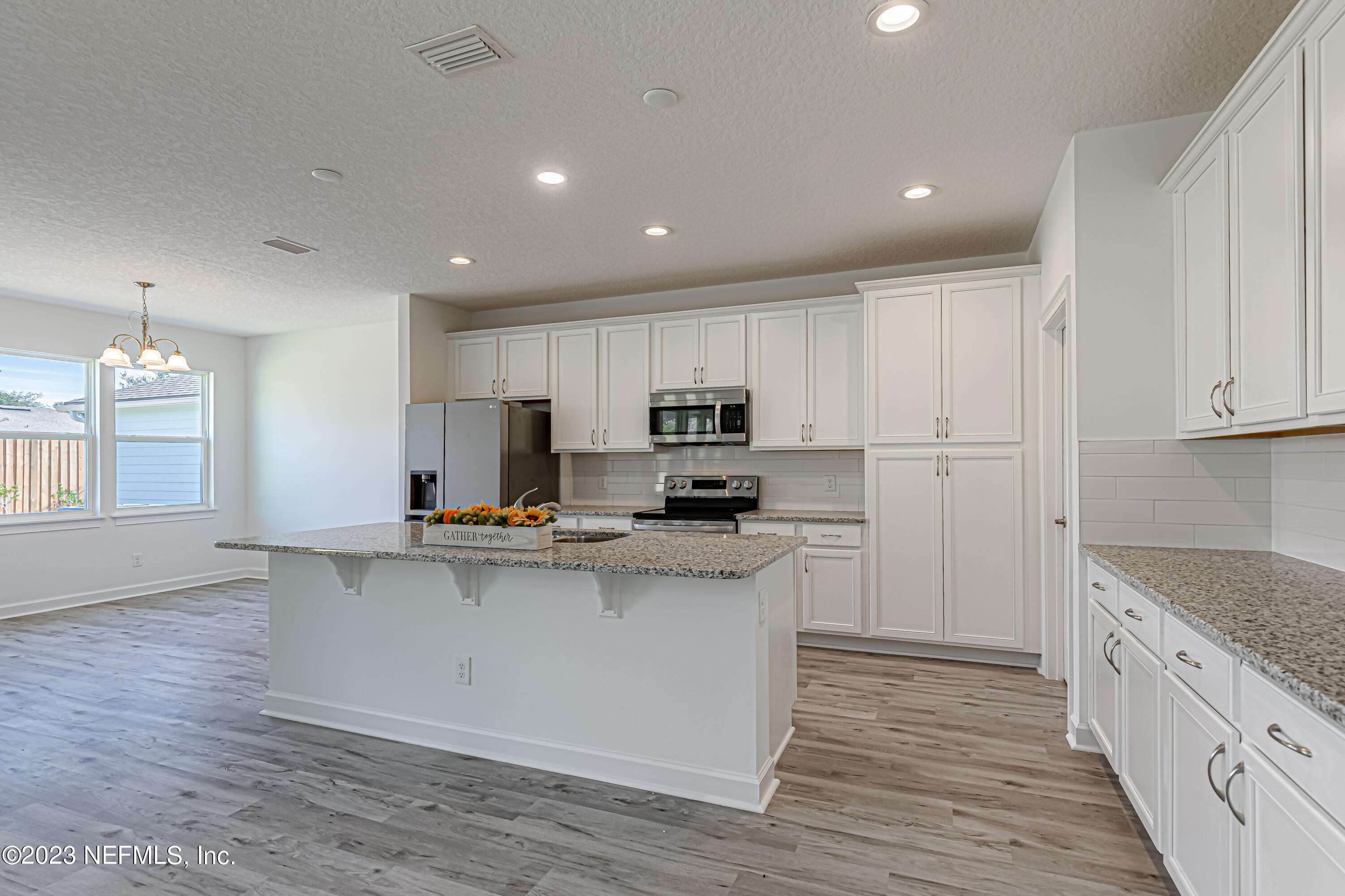 3057 Orange Picker Road Jacksonville, FL 32223 - Photo 6 of 21 a kitchen with stainless steel appliances granite countertop a refrigerator a stove top oven a sink dishwasher and white cabinets with wooden floor