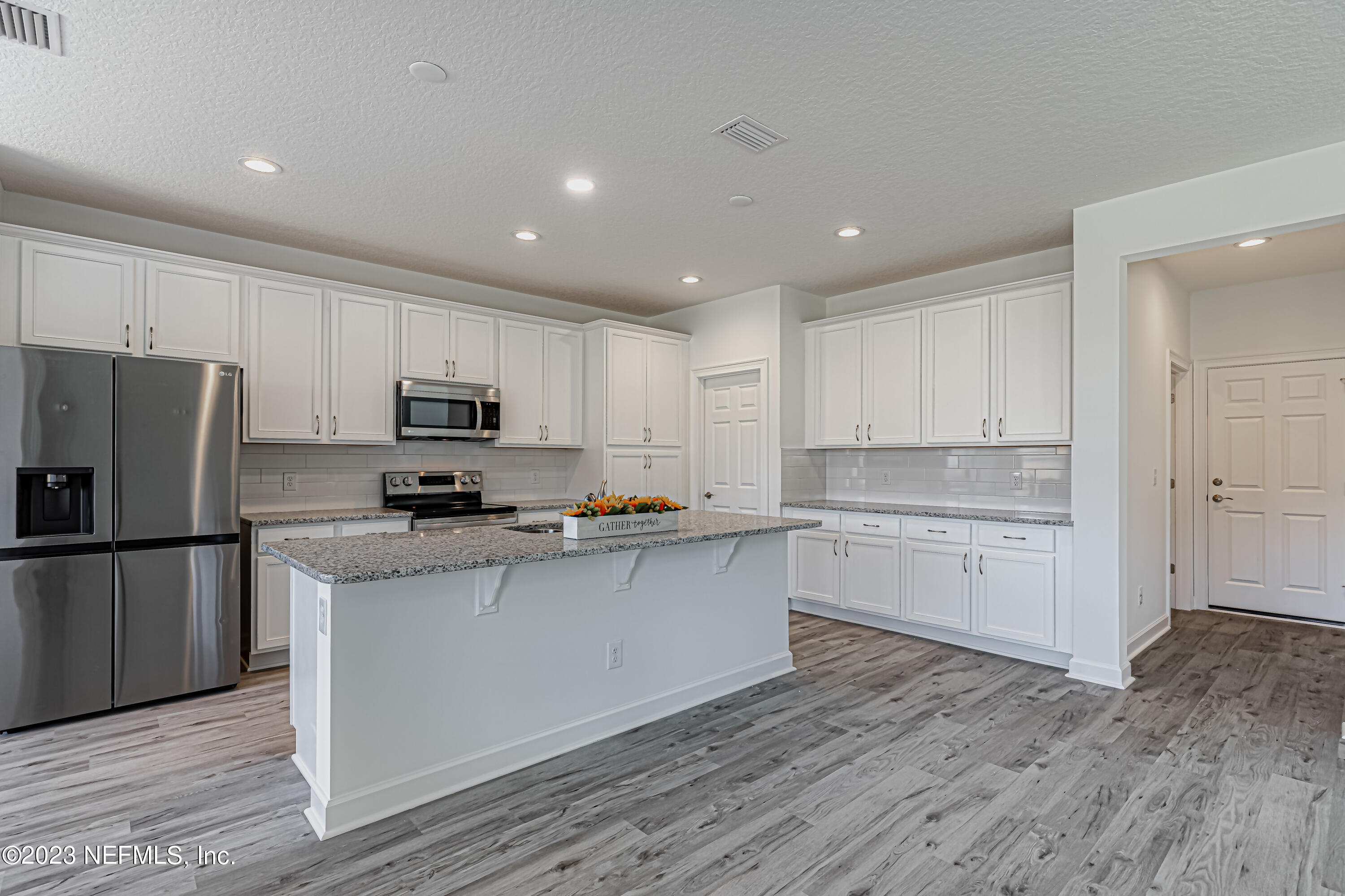 3057 Orange Picker Road Jacksonville, FL 32223 - Photo 7 of 21 a kitchen with granite countertop white cabinets and stainless steel appliances
