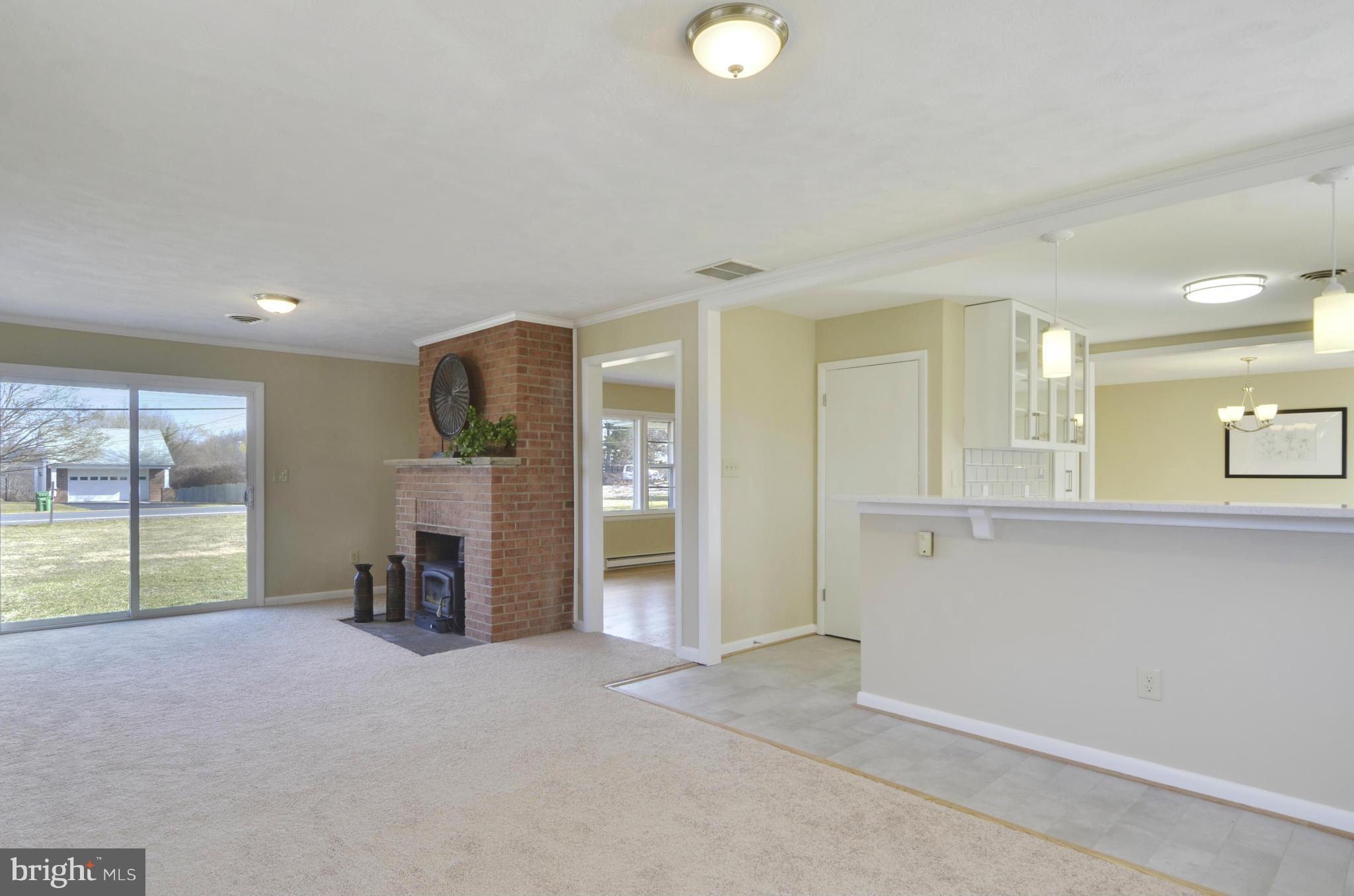28608 Kemptown Road Damascus, MD 20872 - Photo 10 of 30 an empty room with a fireplace and a large window