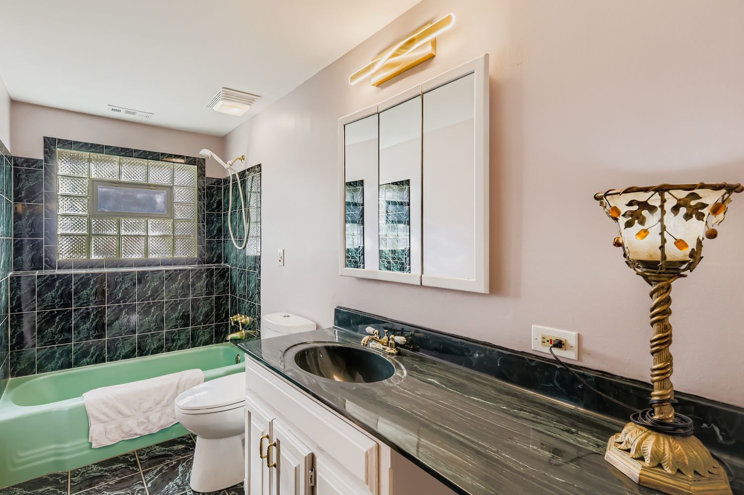 5904 Elm Street Lisle, IL 60532 - Photo 25 of 36 a bathroom with a sink a toilet and a window
