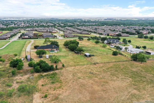 an aerial view of a houses with outdoor space and trees