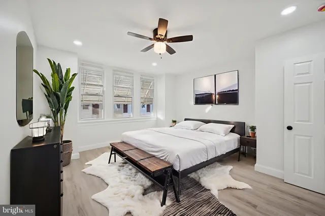 a bedroom with a bed table closet and a window