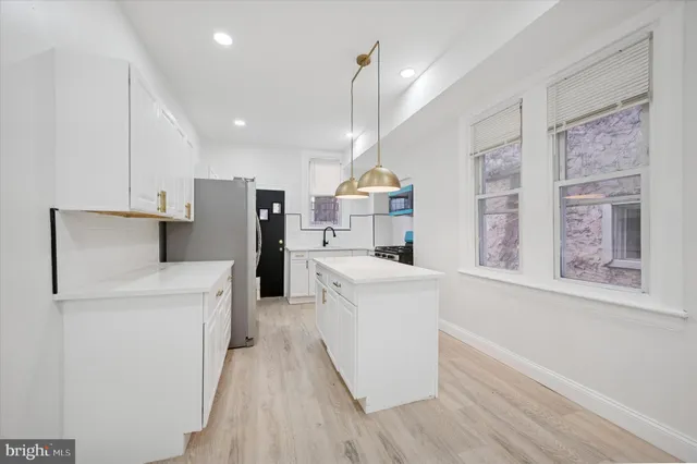 a kitchen with stainless steel appliances a refrigerator and a stove top oven