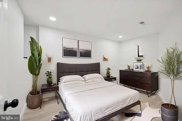 a bedroom with a bed and a potted plant