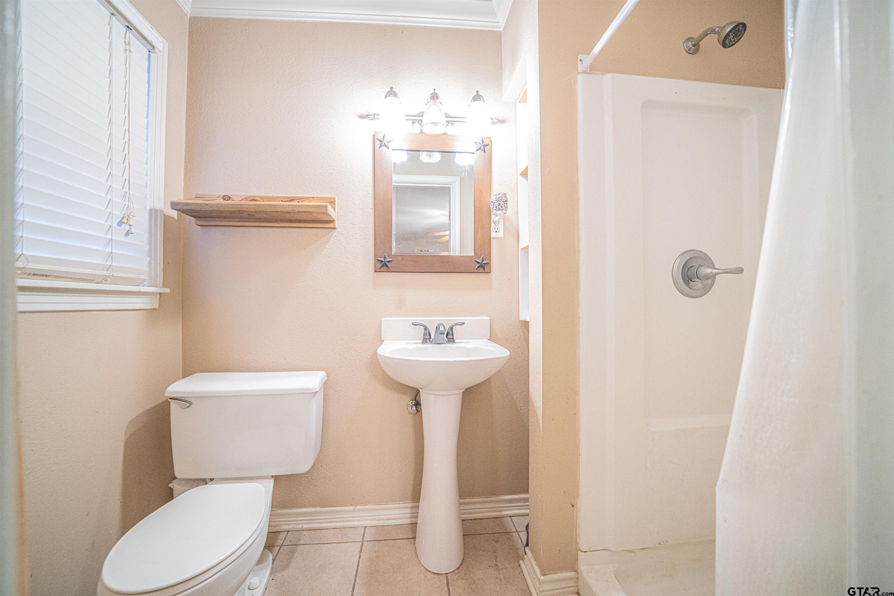 206 Summit Drive Gilmer, TX 75644 - Photo 11 of 24 a bathroom with a toilet sink and mirror