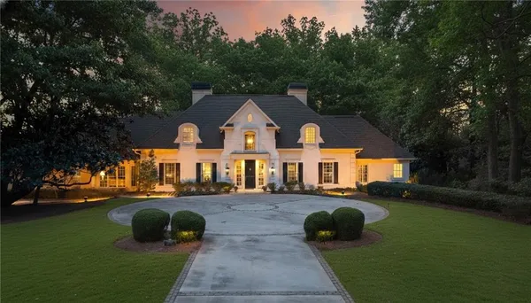 a front view of a house with a yard and trees