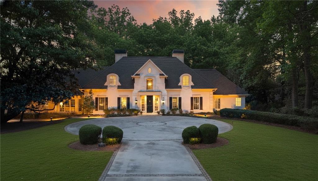 a front view of a house with a yard and trees