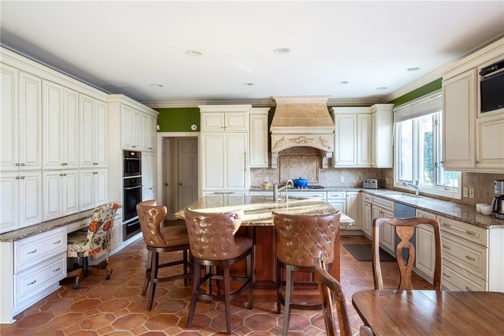 3460 Paces Valley Road Northwest Atlanta, GA 30327 - Photo 11 of 45 a kitchen with granite countertop a table chairs stove and cabinets