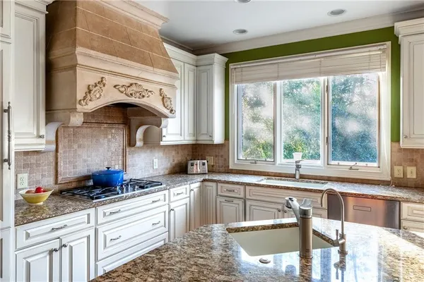a kitchen with granite countertop a stove a sink and a granite counter tops
