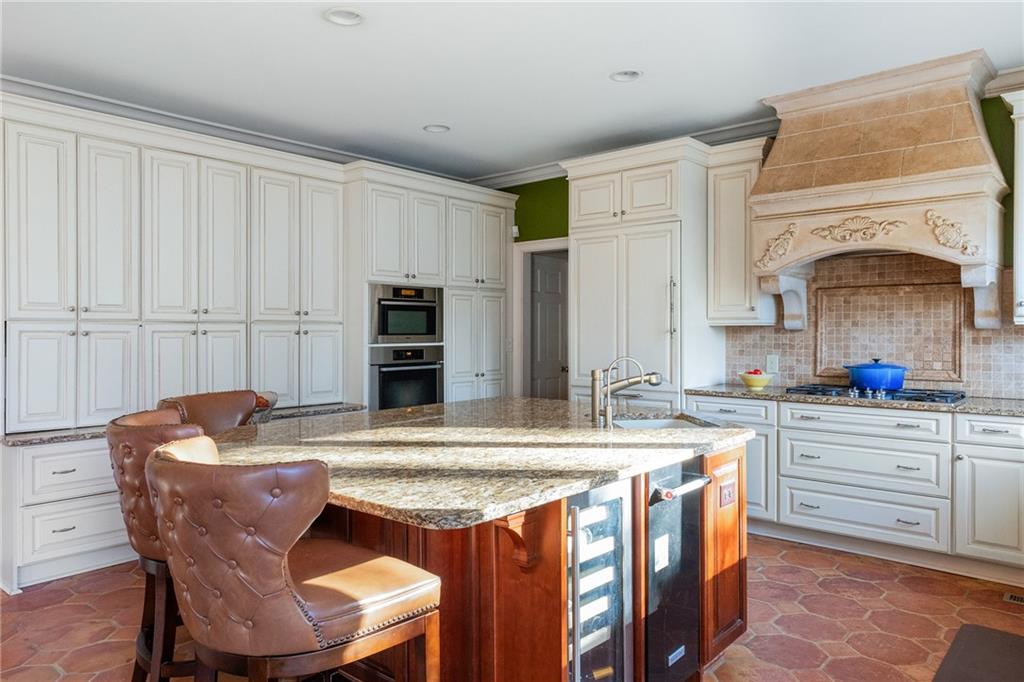 3460 Paces Valley Road Northwest Atlanta, GA 30327 - Photo 13 of 45 a kitchen with stainless steel appliances kitchen island granite countertop a dining table and chairs