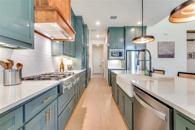 a kitchen with kitchen island a counter space a stove and a sink