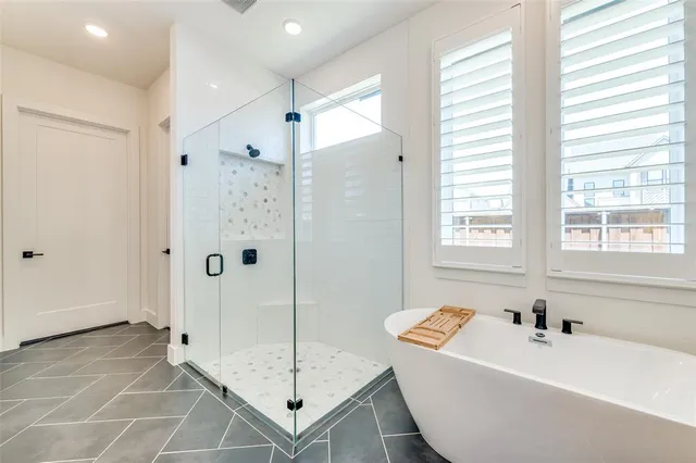 a bathroom with a tub a sink and a shower