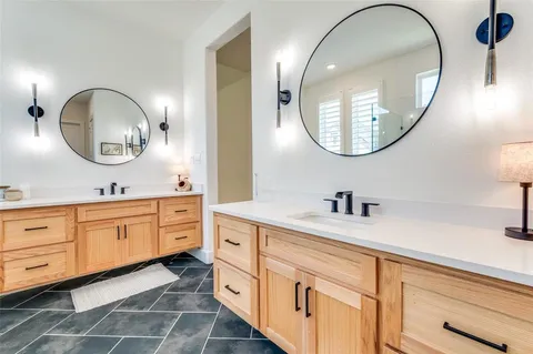a bathroom with a granite countertop double vanity sink and a mirror