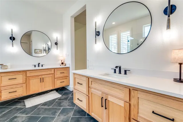 a bathroom with a granite countertop double vanity sink and a mirror