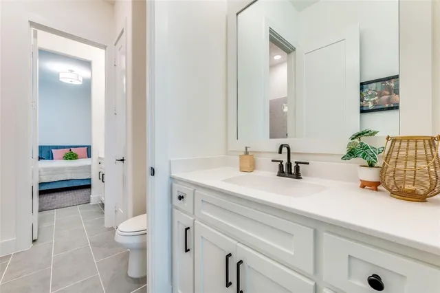 a bathroom with a sink a toilet and a large mirror