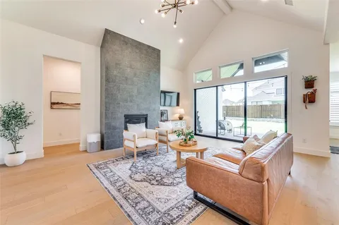 a living room with fireplace furniture and a large window