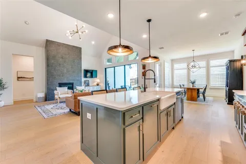 a large kitchen with stainless steel appliances kitchen island granite countertop a sink a stove and a dining table