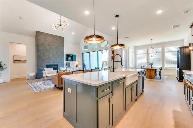 a large kitchen with stainless steel appliances kitchen island granite countertop a sink a stove and a dining table