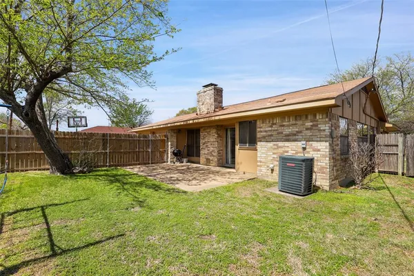 a view of a house with backyard and a tree