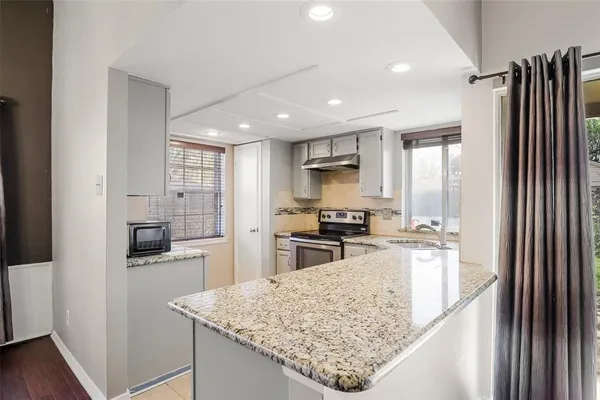 a kitchen with stainless steel appliances granite countertop a refrigerator and a sink