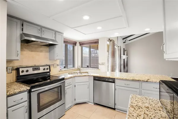 a kitchen with a stove sink and cabinets