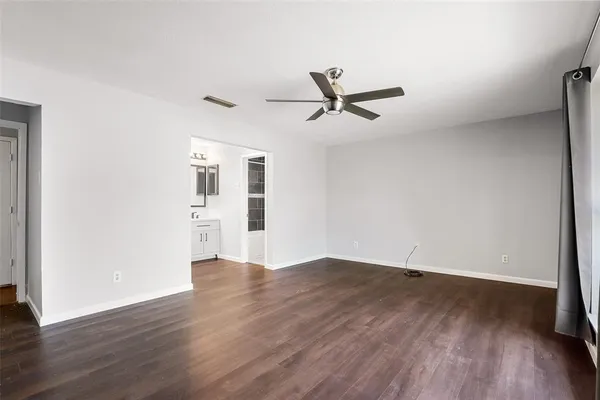 a view of a big room with wooden floor and windows