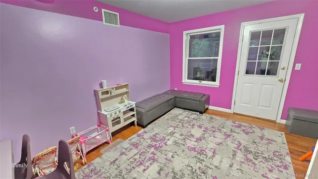 a bedroom with pink walls and pink rug