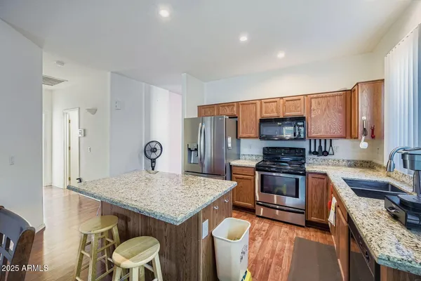 a kitchen with stainless steel appliances granite countertop a sink refrigerator and stove