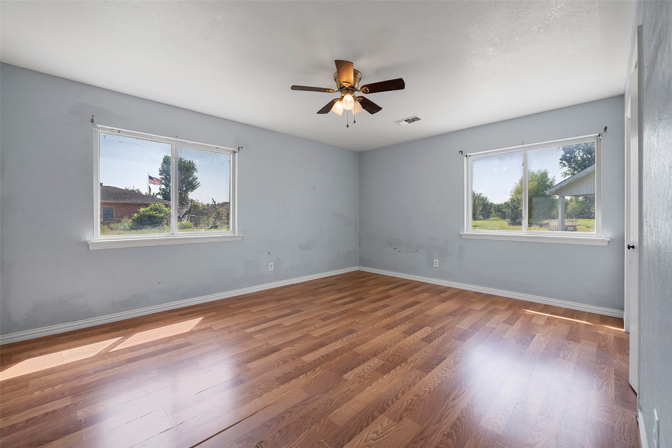 822 Aldine Mail Rte Road Houston, TX 77037 - Photo 35 of 44 a view of an empty room with wooden floor and a window