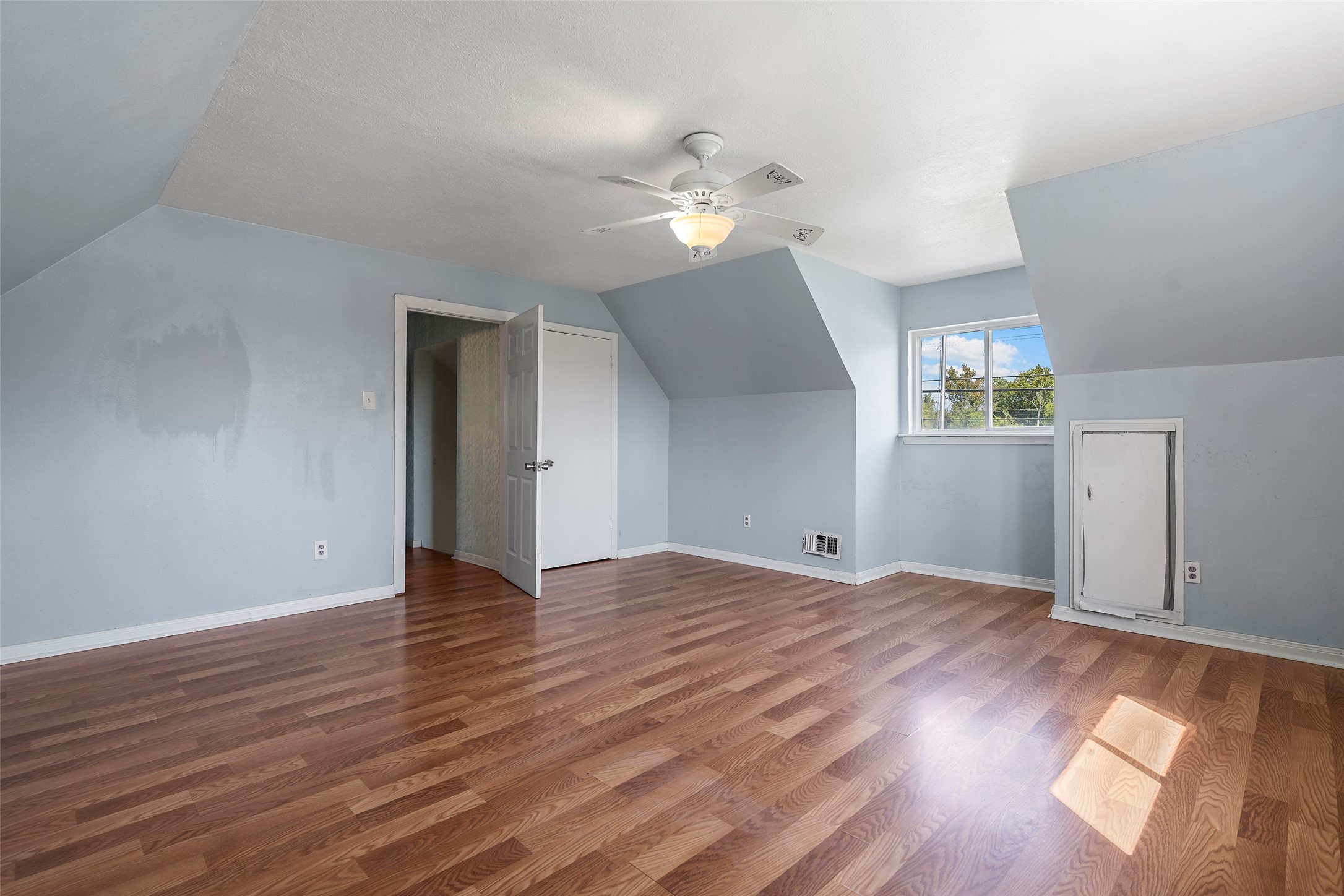 822 Aldine Mail Rte Road Houston, TX 77037 - Photo 41 of 44 an empty room with wooden floor chandelier fan and windows
