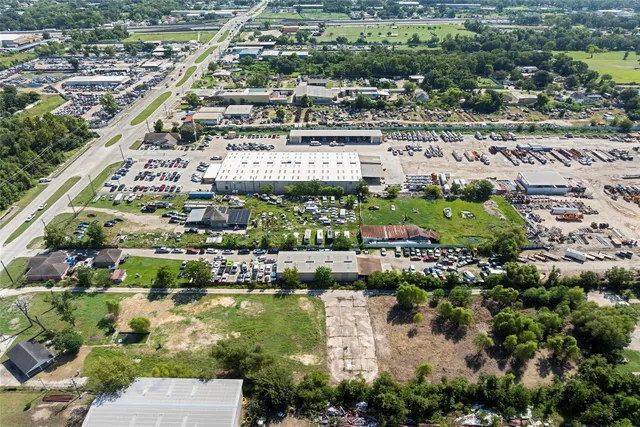 an aerial view of residential houses with outdoor space and trees
