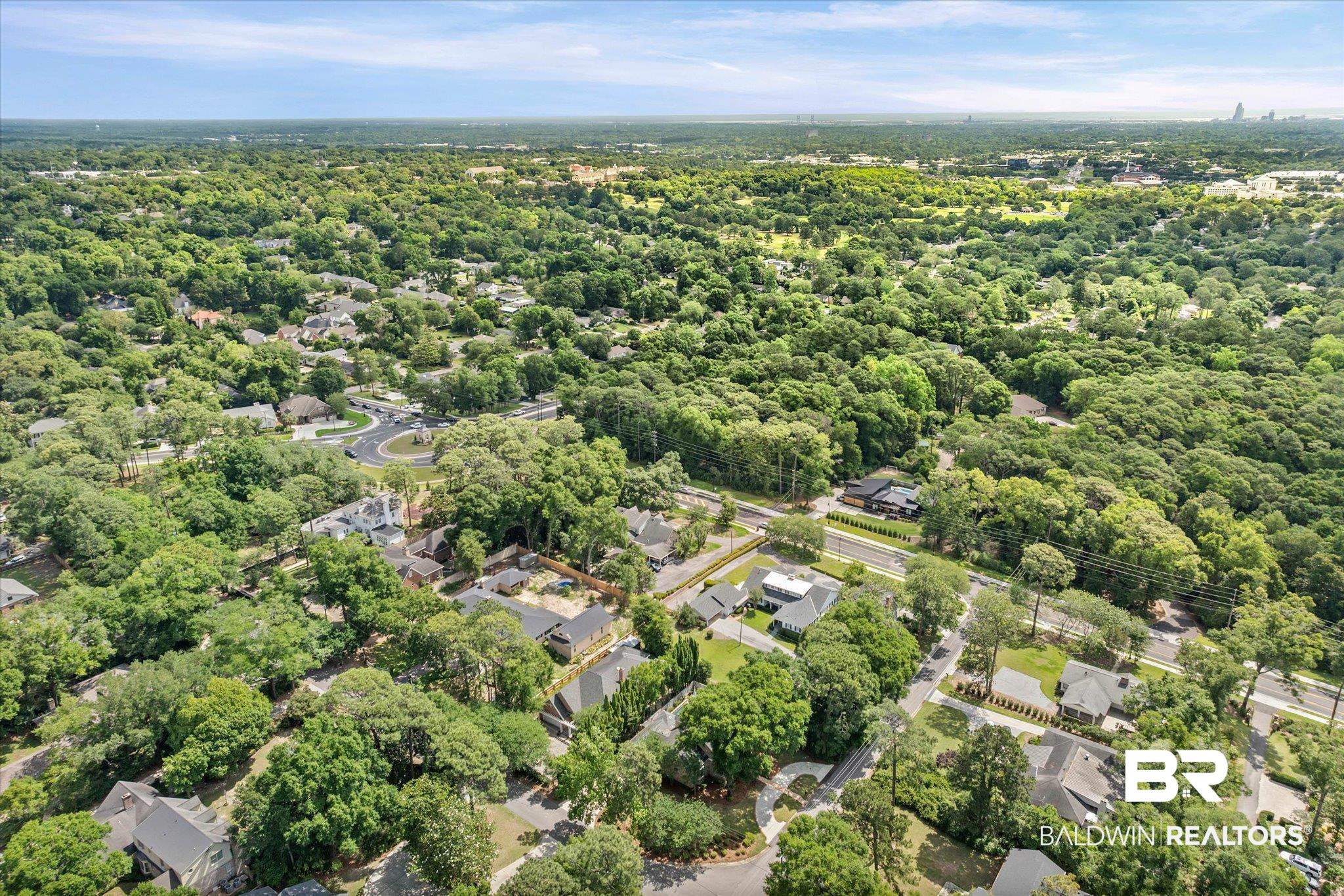 4 Turnout Lane Mobile, AL 36608 - Photo 50 of 53 Expansive aerial perspective showcasing a mature tree canopy, residential properties with varied rooflines, paved roadways, and a prominent roundabout