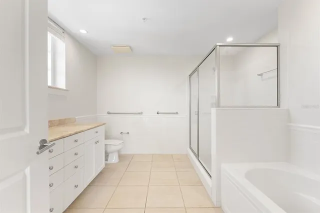 a bathroom with a granite countertop sink a toilet and bathtub