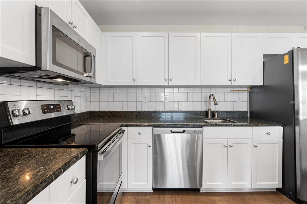 536 Bahia Beach Boulevard, Unit 431C Ruskin, FL 33570 - Photo 4 of 27 a kitchen with granite countertop a sink stainless steel appliances and cabinets