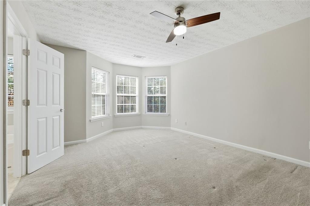 3570 Bogan Mill Road Northeast Buford, GA 30519 - Photo 17 of 31 an empty room with windows and fan