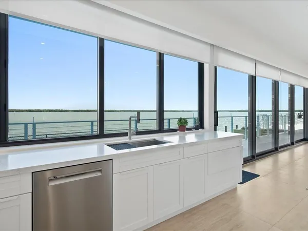 a large white kitchen with cabinets a sink and a stove