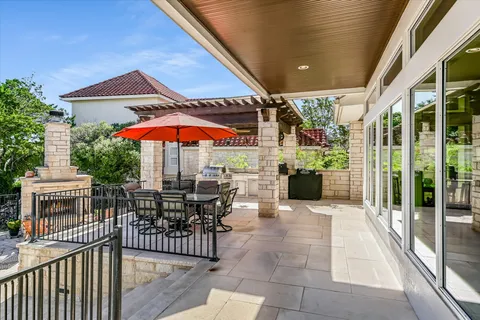 a view of a patio with a table and chairs under an umbrella