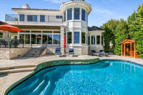 a front view of a house with swimming pool having outdoor seating