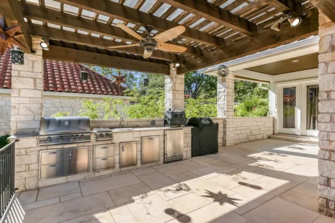 a open kitchen with granite countertop a stove a sink and white cabinets
