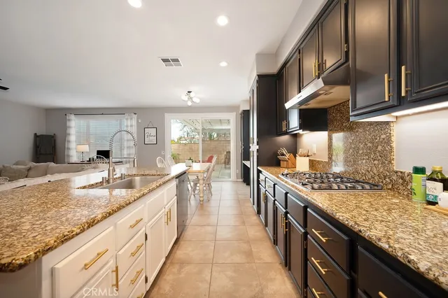 a large kitchen with stainless steel appliances granite countertop a lot of counter space and wooden floors